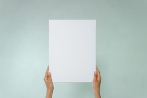 Simple blank canvas held hands on light green background with copy space.